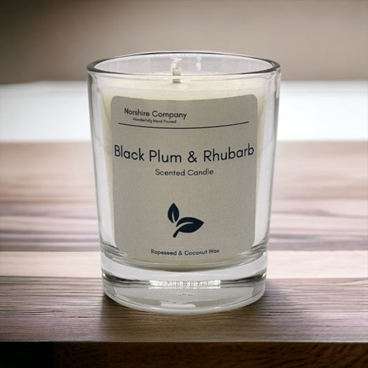 Black plum & rhubarb votive candle on a wooden background